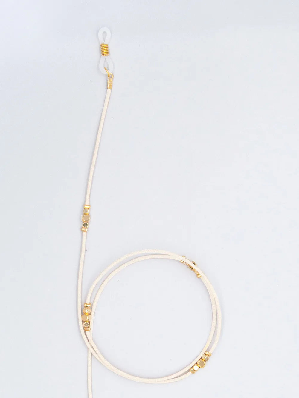 Brillenband crème aus gewachster Baumwollkordel in 1,5 mm Dicke mit goldenen Perlen und Gummihalterung auf weissem Hintergrund