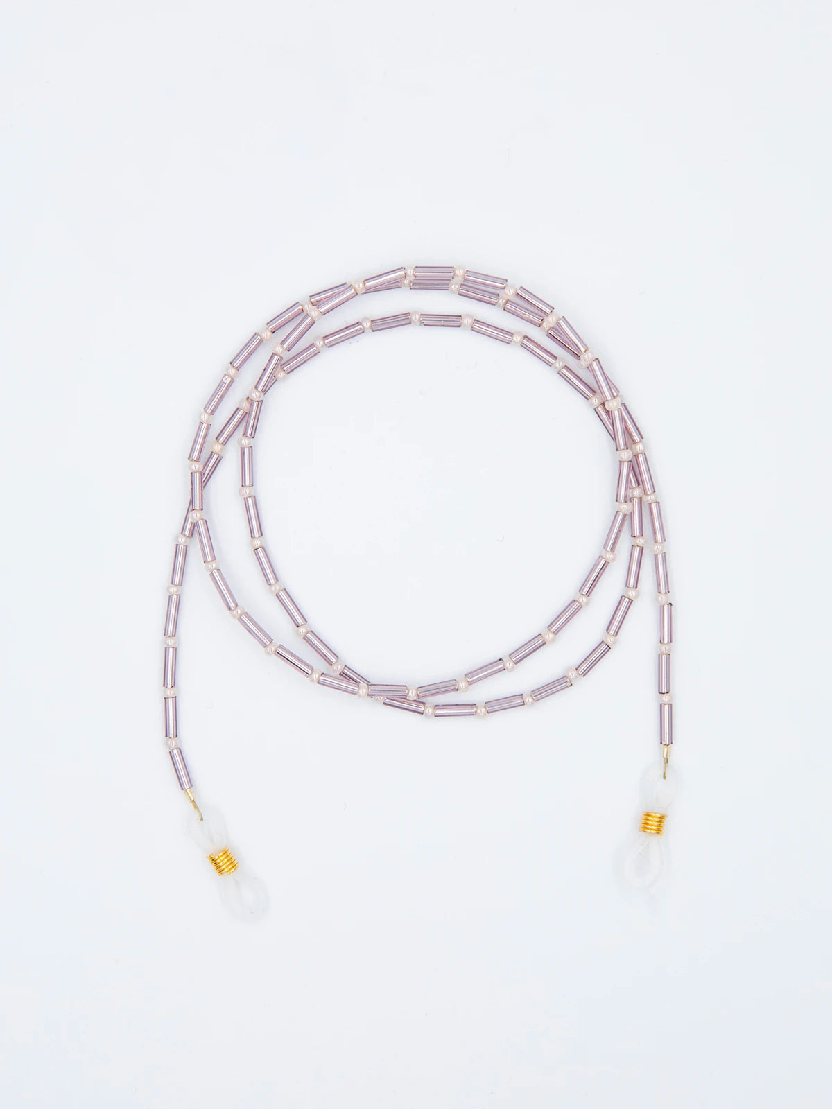 Brillenband aus lila Tube Perlen und crème farbenen feinen Glasperlen mit transparenten Brillengummis auf hellgrauem Hintergrund