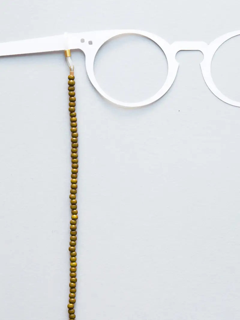 Brillenband aus 4mm oliv Holzperlen an weissem Brillenmodell auf weissem Hintergrund