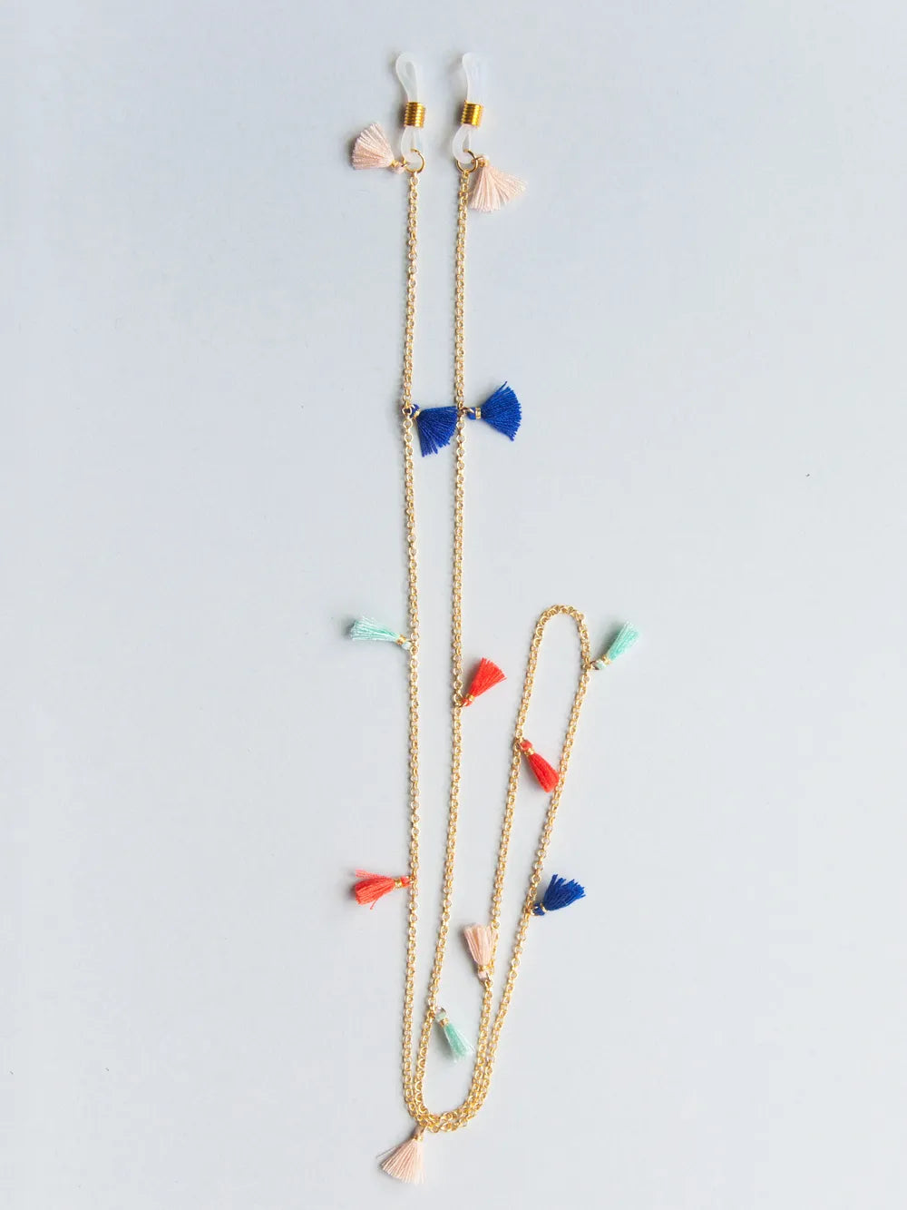 Brillenband aus feiner goldener Kette mit rosa, türkis, korall und dunkelblauen Quasten auf weissem Hintergrund