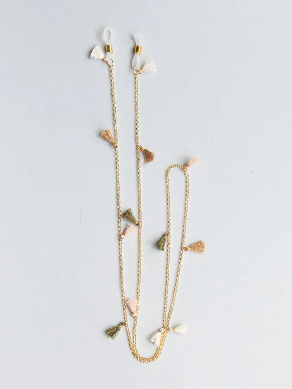 Brillenband aus feiner goldener Kette mit creme, hellbraunen, beigen und oliv Quasten auf weissem Hintergrund