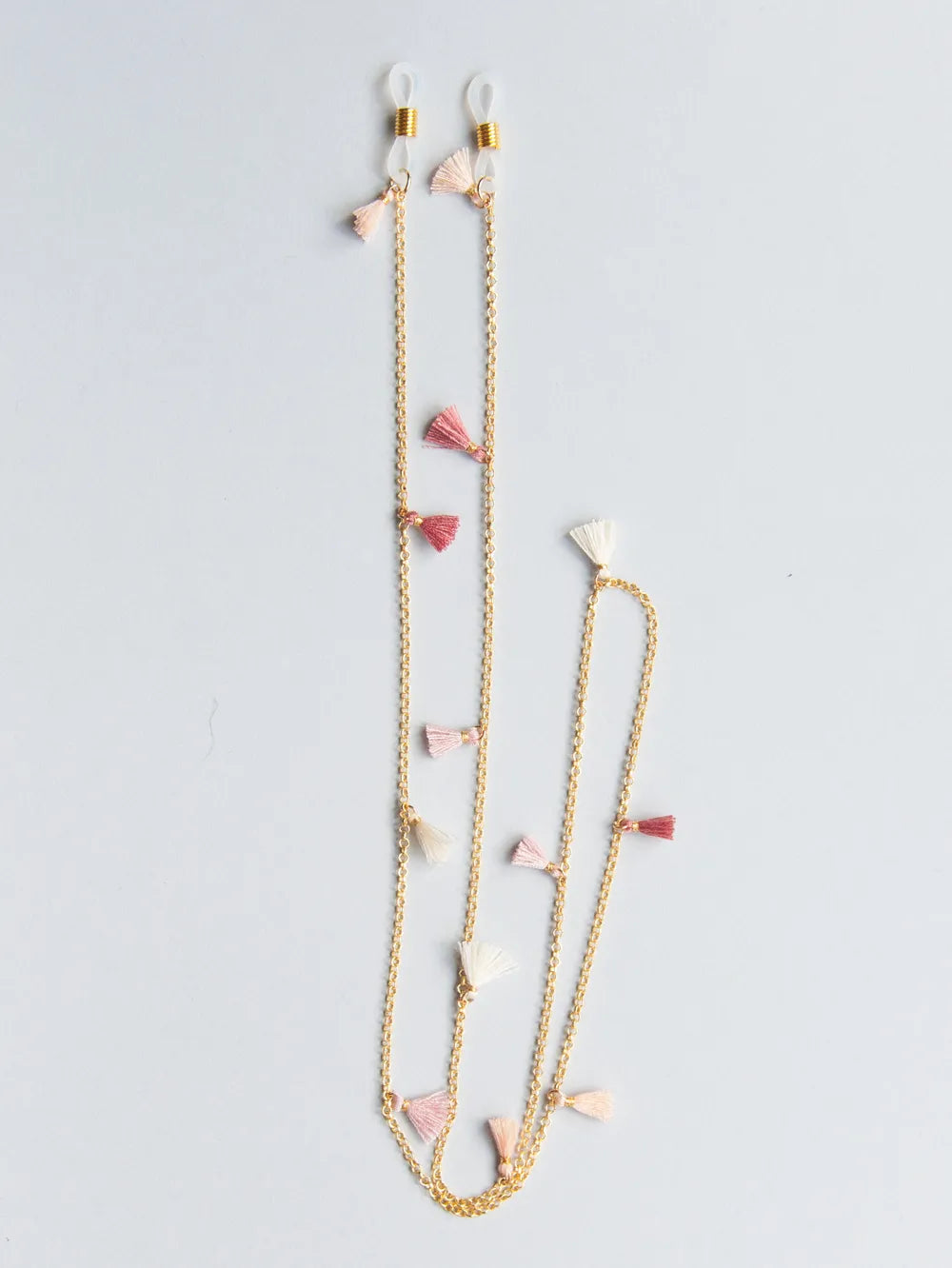 Brillenband aus feiner goldener Kette mit rosa, weissen und hellroten Quasten auf weissem Hintergrund