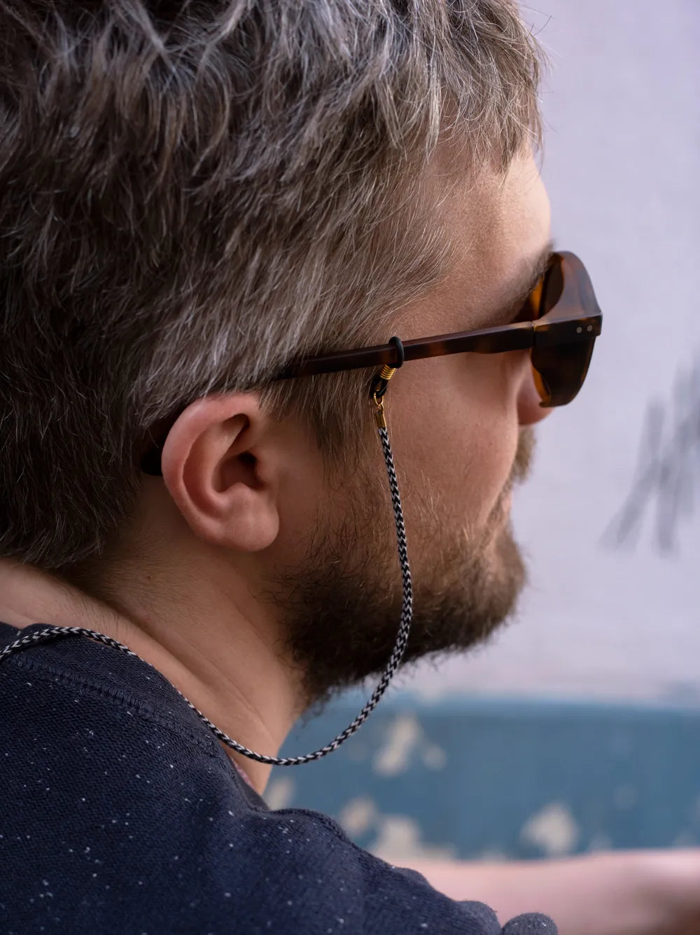 Seitenansicht eines Kopfes mit Sonnenbrille und Brillenband in schwarz und weiss