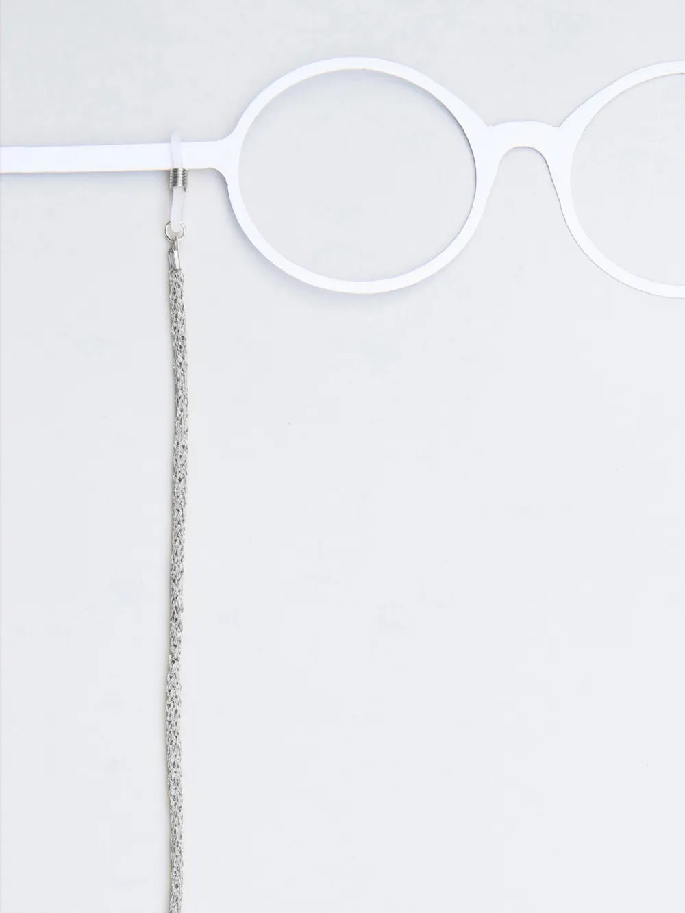 Brillenband aus geflochtener glänzender Kordel silber an weissem Brillenmodell auf weissem Hintergrund