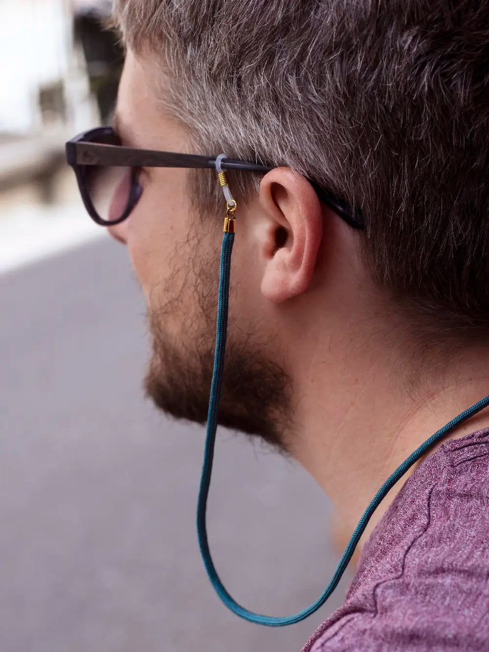 Seitenansicht einer Person mit Sonnenbrille mit Brillenband Paracord petrol