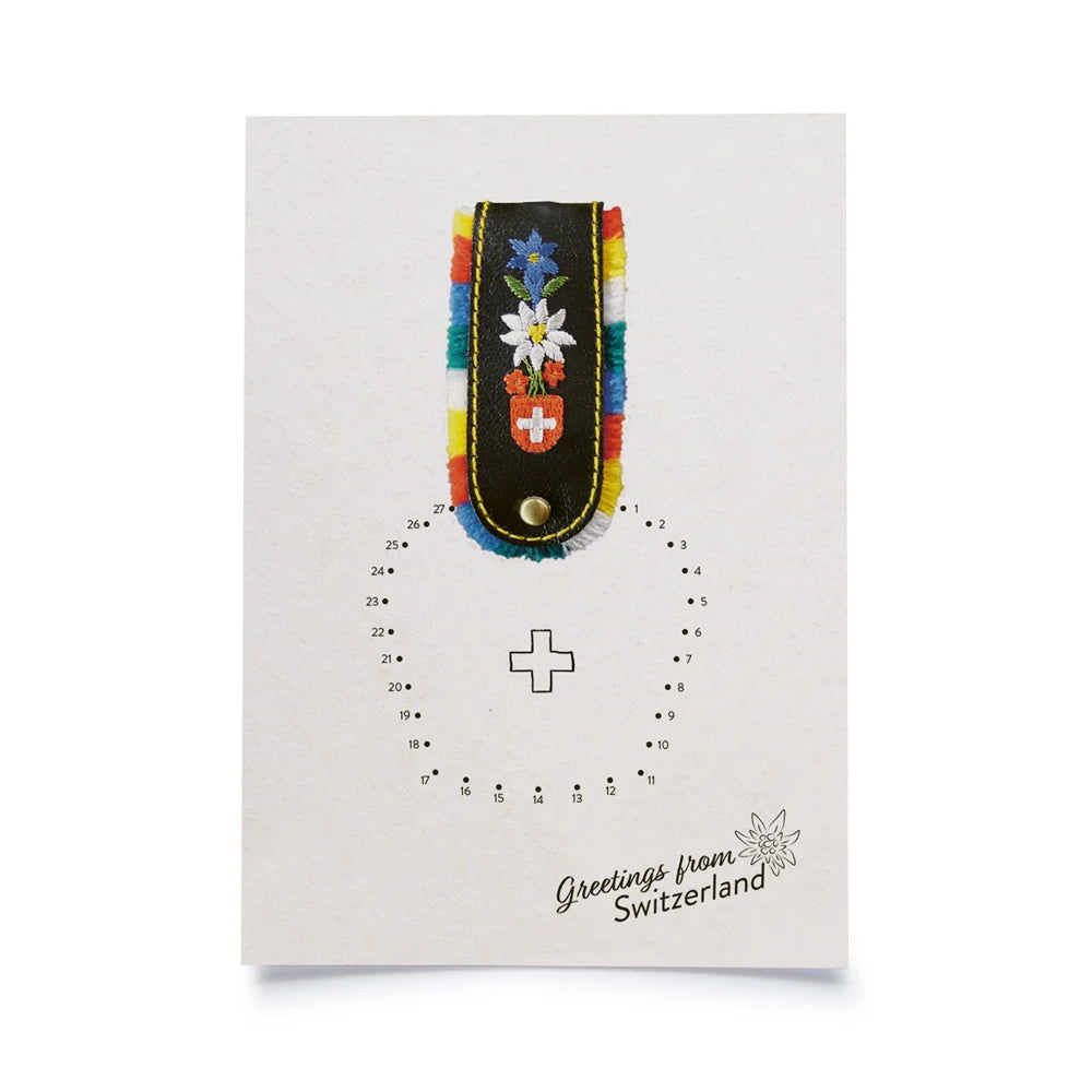 Postkarte weiss mit Malen nach Zahlen Motiv Kuhglocke, in unterer rechter Ecke Schriftzug Greetings from Switzerland