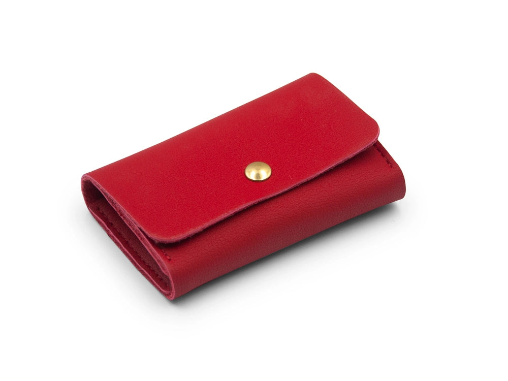 Rotes Portemonnaie aus veganem Leder mit goldenem Druckknopf auf weissem Untergrund