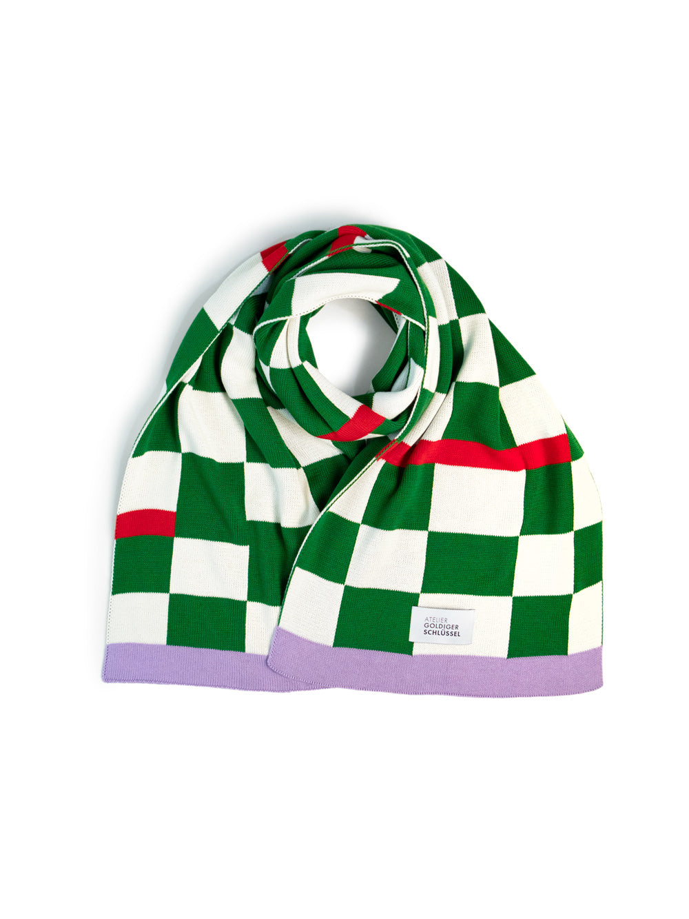 grün-weiss karierter Schal mit violettem Ende liegt auf weissem Hintergrund.