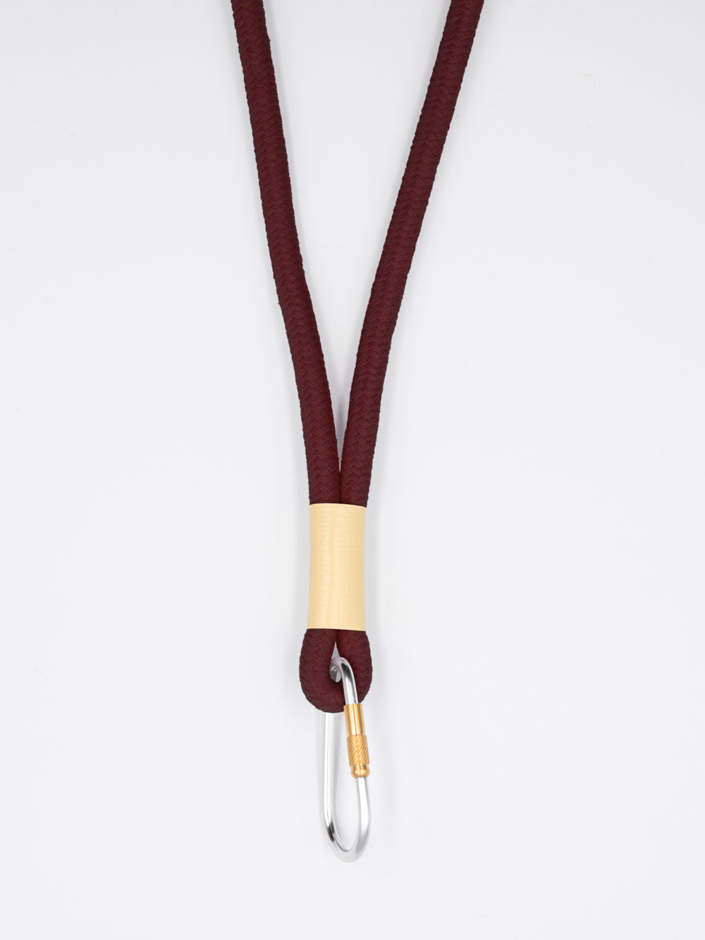 Braunes Schlüsselband aus Baumwollkordel mit silbernem Karabiner auf weissem Untergrund.