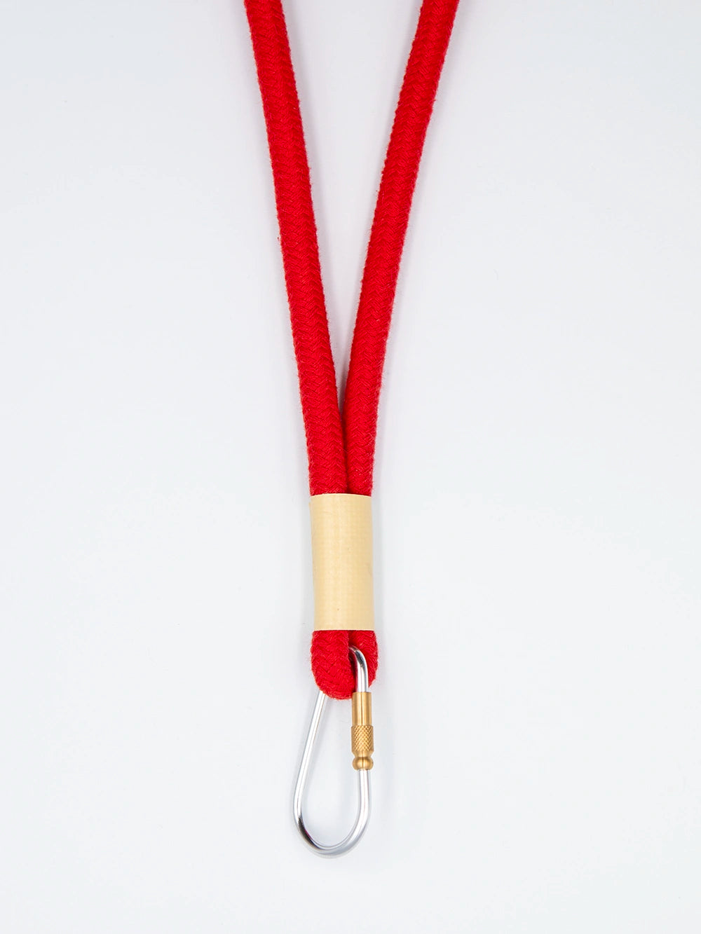 Rotes Schlüsselband aus Baumwollkordel mit silbernem Karabiner auf weissem Untergrund.