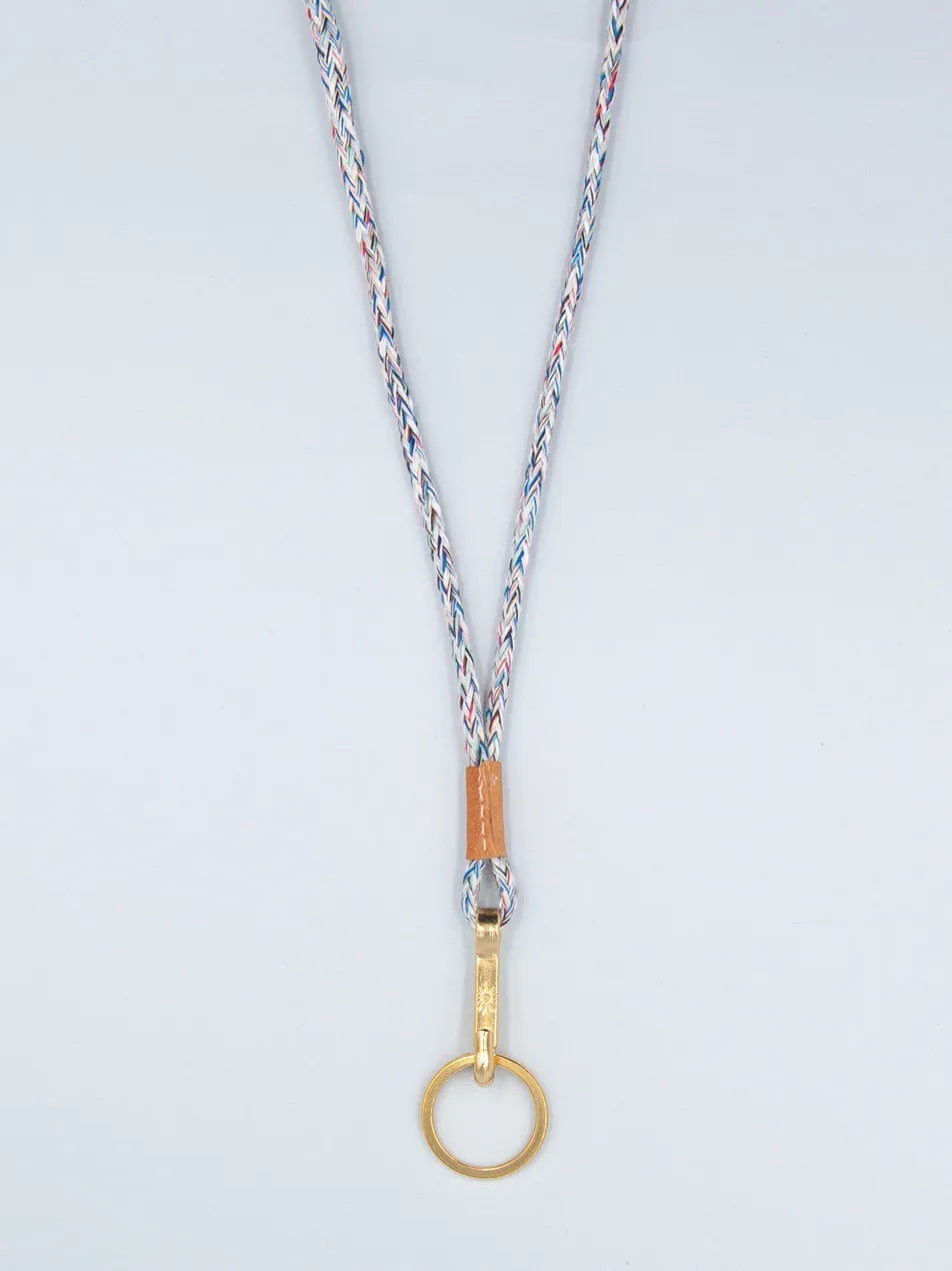 Schlüsselband aus Baumwollkordel hellblau meliert mit Lederabschluss und goldenem Karabiner mit Schlüsselring vor weissem Hintergrund