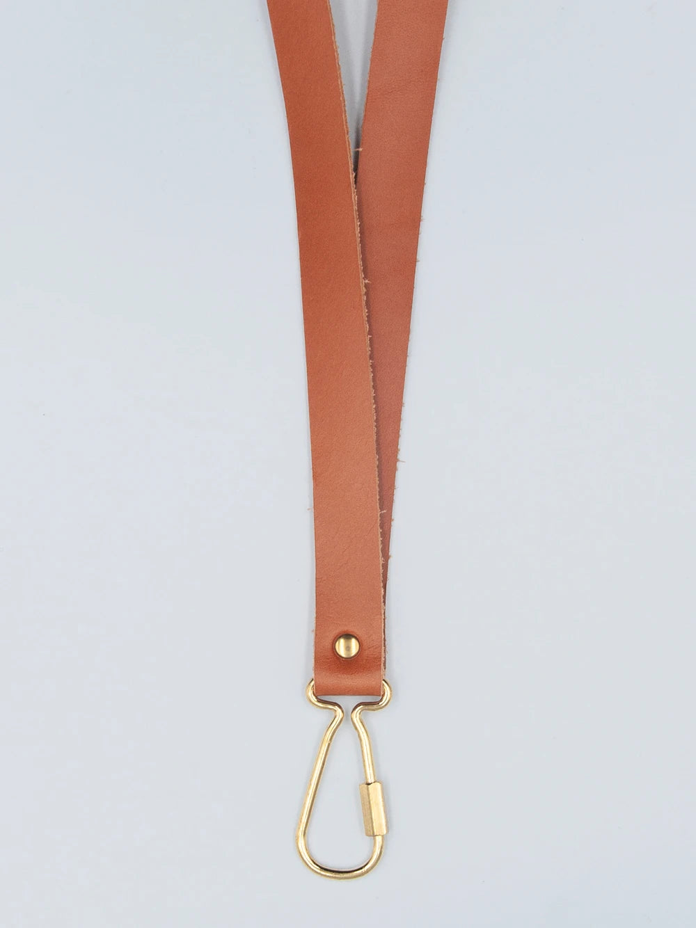 Braunes Lederschlüsselband mit goldenem Karabiner vor weissem Hintergrund