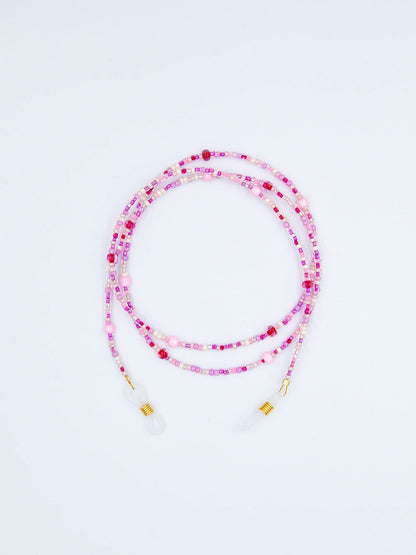 Brillenband aus Glasperlen in einem Mix aus verschiedenen Rosa und Pinktönen auf weissem Hintergrund