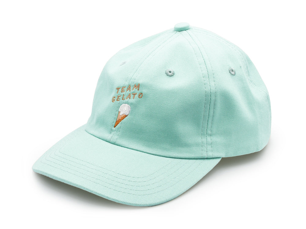 Mint farbenes Dad Cap aus Bio-Baumwolle mit der beigen Stickerei Team Gelato und einem ebenfalls gestickten Eis auf weissem Hintergrund