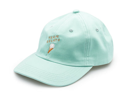 Mint farbenes Dad Cap aus Bio-Baumwolle mit der beigen Stickerei Team Gelato und einem ebenfalls gestickten Eis auf weissem Hintergrund