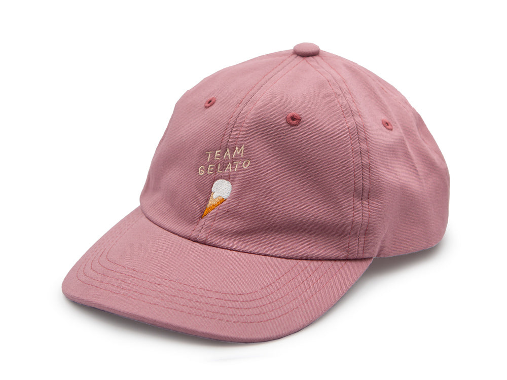 Rosa farbenes Dad Cap aus Bio-Baumwolle mit der beigen Stickerei Team Gelato und einem ebenfalls gestickten Eis auf weissem Hintergrund