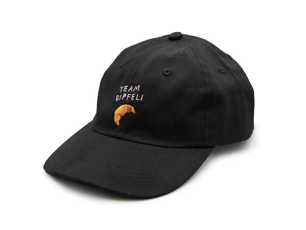 Schwarzes Cap mit grünem gesticktem Schriftzug Team Gipfeli und einem gestickten Croissant auf weissem Hintergrund.
