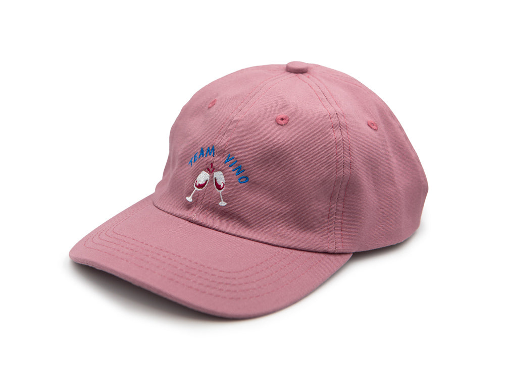 Rosa farbenes Cap mit blauem gesticktem Schriftzug Team Vino und zwei gestickten Weingläsern auf weissem Hintergrund.