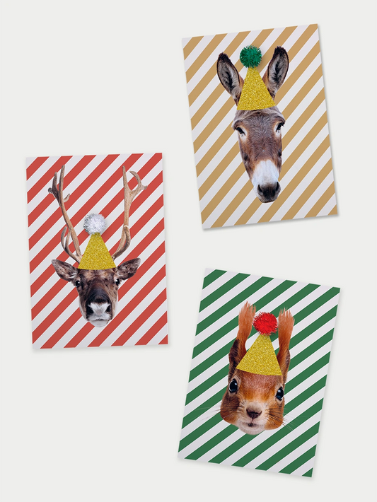 Drei Faltkarten, eine rot-weiss schräg gestreift mit einem Rentierkopf mit goldenem Hut und weissem Pompon, eine beige-weiss schräg gestreift mit Eselskopf mit goldenem Hut und grünem Pompon und eine grün-weiss schräg gestreift mit Eichhörnchenkopf mit goldenem Hut und rot Pompon auf beigem Hintergrund