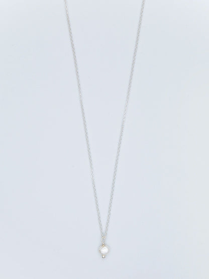 Halskette aus Sterlingsilber mit Anhänger aus Süsswasserperle auf hellgrauem Untergrund.