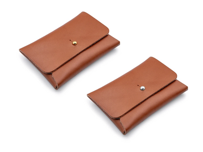 zwei braune Kartenportemonnaies aus Leder mit Kopfnieten als Verschlüssen auf weissem Untergrund