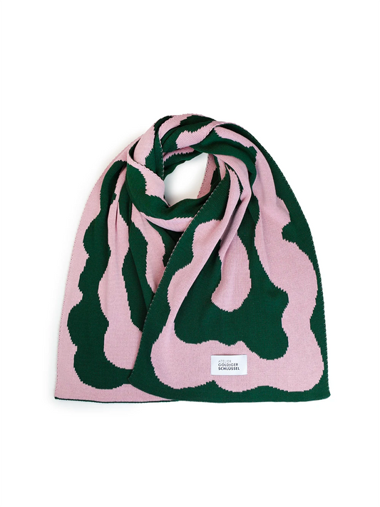Grün rosa gemusterter gestrickter Schal aus Baumwolle mit dem Label von Atelier Goldiger Schlüssel auf weissem Untergrund.
