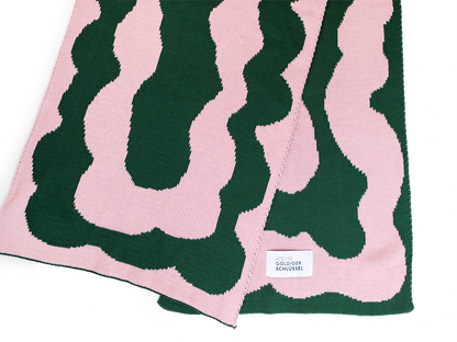 Detailansicht eines Grün rosa gemusterten Schals aus Bio-Baumwolle vom Label von Atelier Goldiger Schlüssel auf weissem Untergrund.