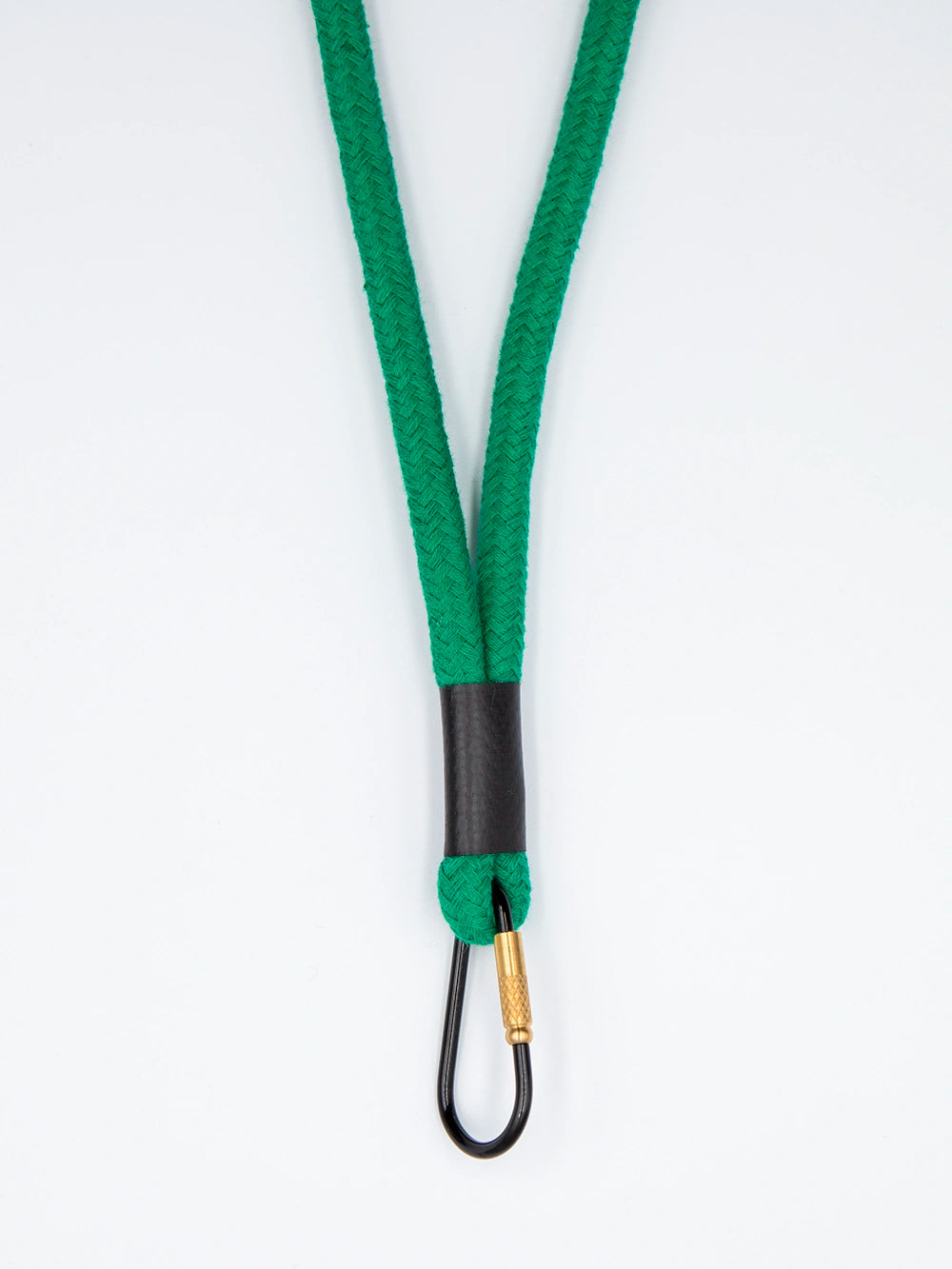 Grünes Schlüsselband aus Baumwollkordel mit schwarzem Karabiner auf weissem Untergrund.