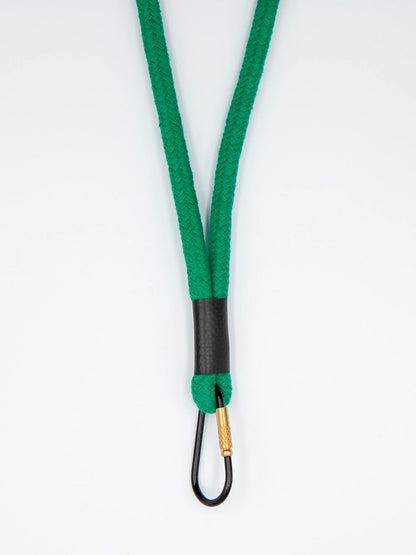 Grünes Schlüsselband aus Baumwollkordel mit schwarzem Karabiner auf weissem Untergrund.