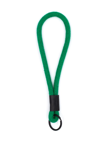Grüner Schlüsselanhänger aus Kordel  mit schwarzem Schlüsselring auf weissem Untergrund.