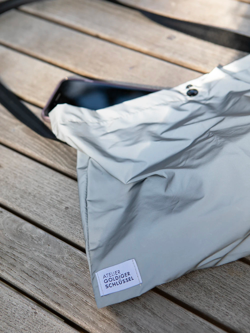 Detailansicht einer reflektierenden Tasche mit dem Label «Atelier Goldiger Schlüssel».