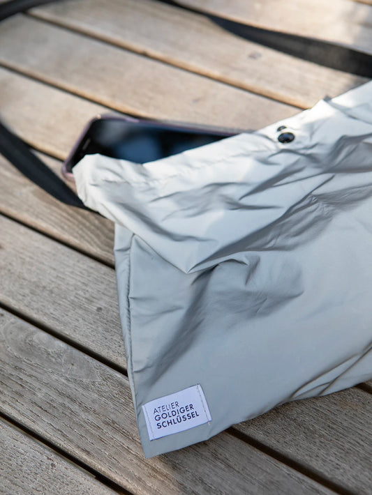 Detailansicht einer reflektierenden Tasche mit dem Label «Atelier Goldiger Schlüssel».